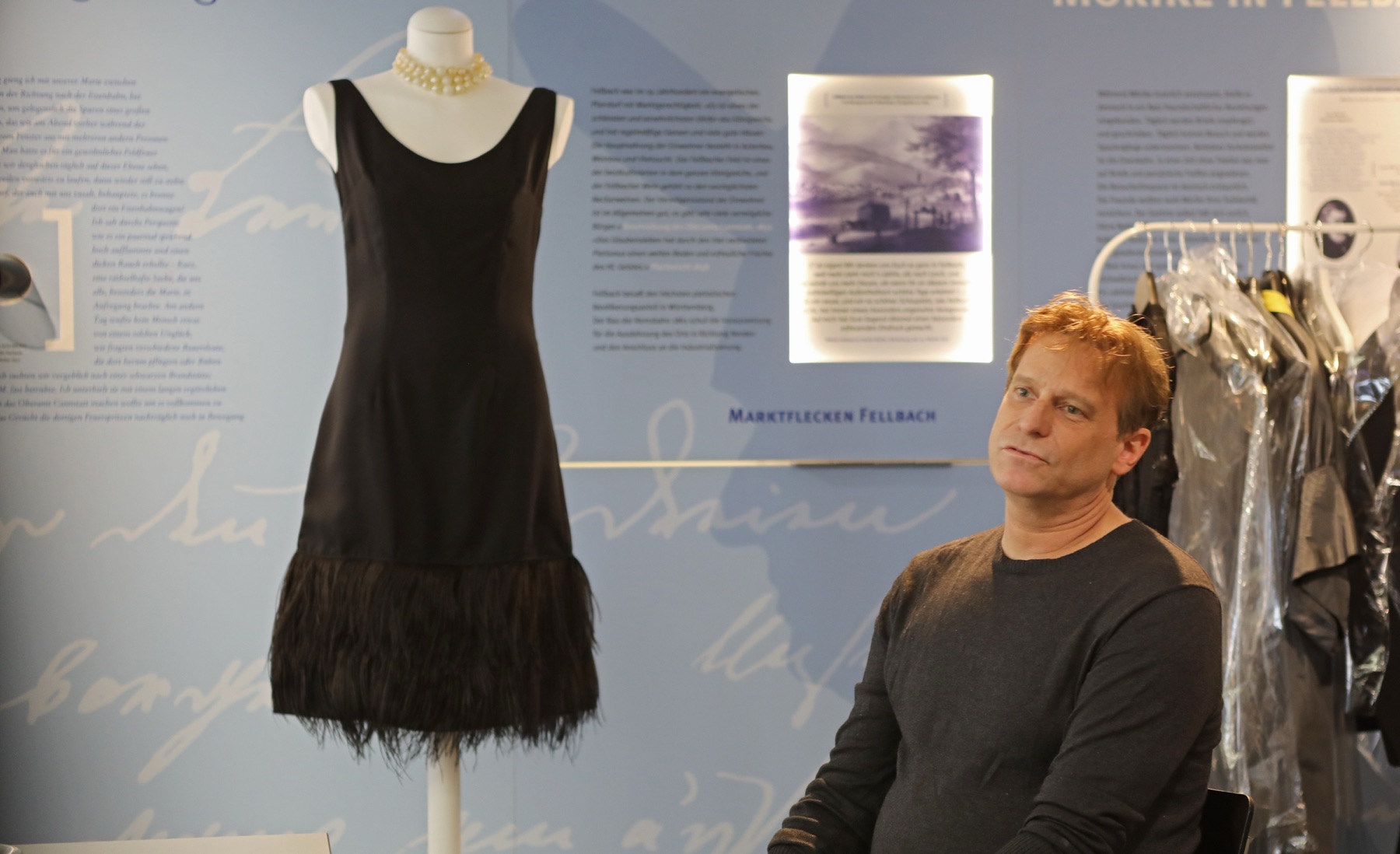 Christian Bräu neben einem schwarzen Kleid in der Ausstellung Das kleine Schwarze im Stadtmuseum Fellbach